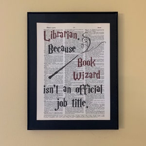 May include: A black framed print with a white background and black text. The text reads "Librarian. Because Book Wizard isn't an official job title."