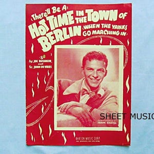 May include: Sheet music cover with a red background and the title "There'll Be A Hot Time In The Town Of Berlin". Features a photo of Frank Sinatra and the text "Sheet Music".