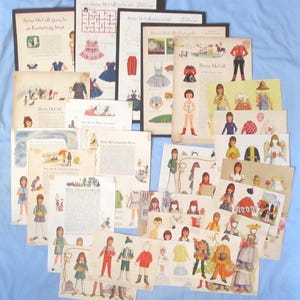 May include: A collection of vintage Betsy McCall paper doll pages featuring various illustrated outfits, accessories, and stories. Each page displays colorful character figures, clothing items with tabs for cutting, and printed text narratives.