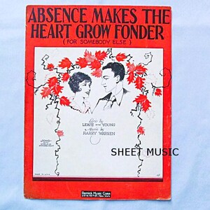 May include: A vintage sheet music cover with a red background and a black and white illustration of a couple. The title of the song is "Absence Makes the Heart Grow Fonder (For Somebody Else)". The lyrics are by Lewis Young and the music is by Harry Warren.