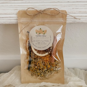 Peut inclure: Un sachet transparent avec une ficelle, contenant un kit pour pot-pourri pour cuisini&egrave;re. Le kit comprend de la camomille s&eacute;ch&eacute;e, du calendula, des tranches d'orange, de la vanille, des b&acirc;tons de cannelle et de la badiane. L'&eacute;tiquette indique "Golden Glow".
