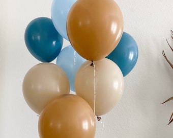 Peut inclure: Un groupe de ballons dans des tons de bleu et de brun. Les ballons sont attachés ensemble avec une ficelle blanche.