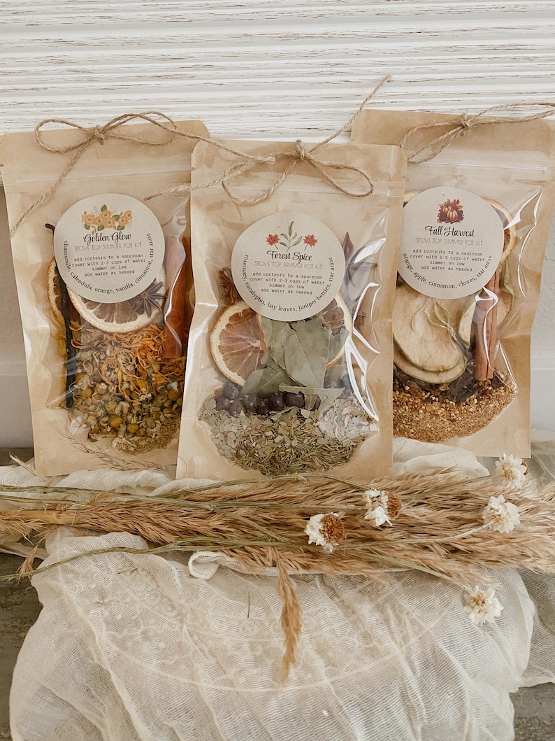 Peut inclure: Trois sachets en papier kraft attach&eacute;s avec de la ficelle, contenant chacun des herbes et &eacute;pices s&eacute;ch&eacute;es. Les sachets sont &eacute;tiquet&eacute;s "Golden Glow", "Forest Spice" et "Fall Harvest". Le sachet "Golden Glow" comprend calendula, orange, vanille et cannelle. Le sachet "Forest Spice" contient eucalyptus, feuilles de laurier et baies de geni&egrave;vre.