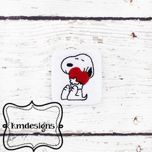 May include: A white cartoon dog holding a red heart in its arms. The dog is smiling and has a black outline.
