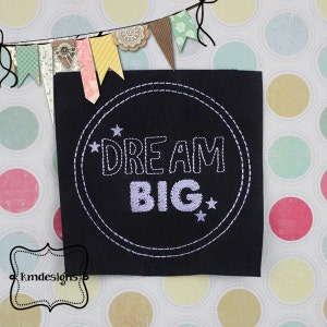 May include: A black fabric patch with a white circle and the text "DREAM BIG" in white with stars on either side of the text.