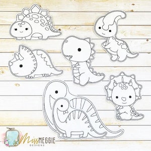 May include: A collection of seven black and white dinosaur illustrations with cute, cartoonish features. The dinosaurs include a Stegosaurus, a Parasaurolophus, a Triceratops, a Tyrannosaurus Rex, and others. The MissMeggie Designs logo is in the lower left corner.