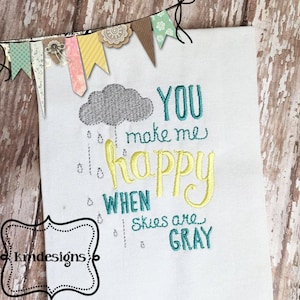 Peut inclure: Broderie sur un tissu blanc avec un nuage gris, des gouttes de pluie et le texte "You make me happy when skies are gray".