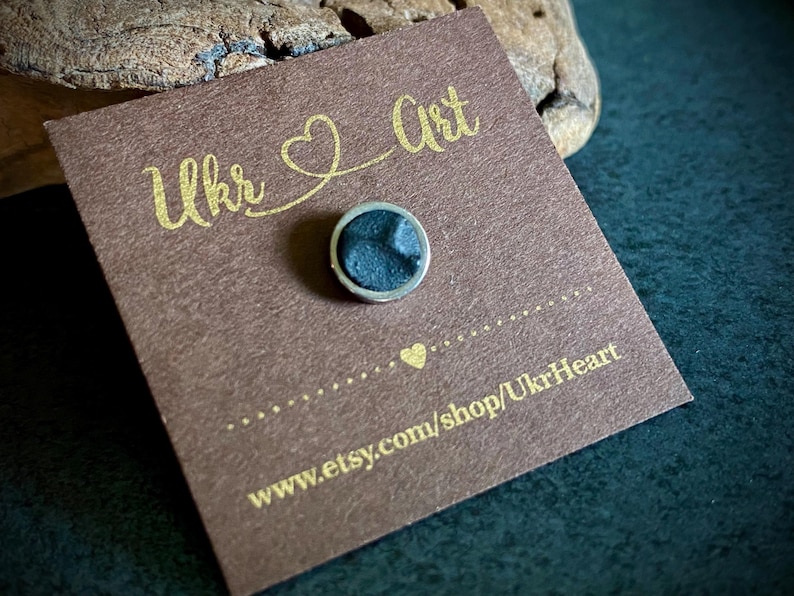 May include: A small, round, dark blue pin with a silver border is displayed on a brown card. The card has gold text that reads "Ukr Art" and "UkrHeart". The Etsy shop URL is also visible.
