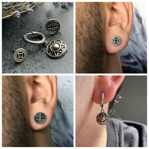 May include: A set of three silver earrings featuring a circular design with a sunburst pattern. The earrings are shown on a person's ear.