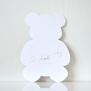May include: White teddy bear shaped card with a dotted line design and the text "Lunita Paperie" and the website address "lunitapaperie.com".