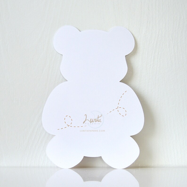 May include: White teddy bear shaped card with a dotted line design and the text "Lunita Paperie" and the website address "lunitapaperie.com".