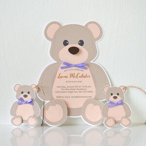 May include: A teddy bear-shaped invitation for a first birthday party. The invitation features the text "Join us to celebrate Lucas McCalister as he turns one!" with the date, time, and location of the party. The invitation is decorated with two smaller teddy bears.
