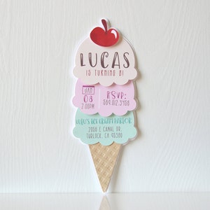 Puede incluir: Una invitaci&oacute;n de cumplea&ntilde;os con forma de cono de helado para el octavo cumplea&ntilde;os de Lucas. La invitaci&oacute;n presenta una cereza roja en la parte superior de un cono de helado de tres bolas con el texto "Lucas cumple 8 a&ntilde;os!" La invitaci&oacute;n incluye la fecha, la hora, la informaci&oacute;n de RSVP y la ubicaci&oacute;n de la fiesta en Lulu's Ice Cream Parlor.