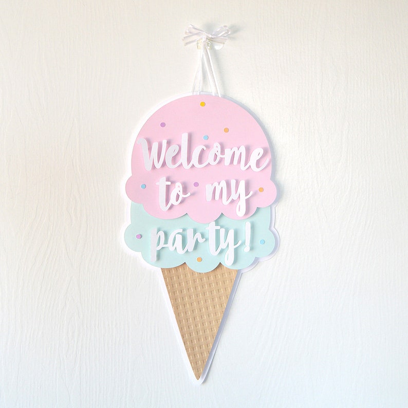 May include: A pink and blue ice cream cone party sign with the text "Welcome to my party!" in white lettering.