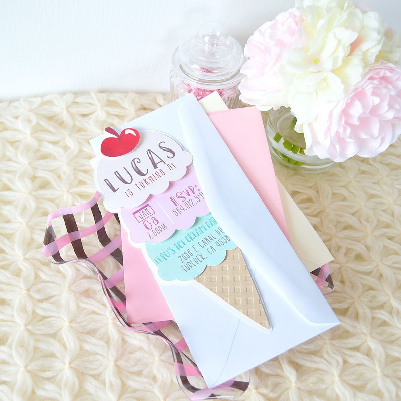 Puede incluir: Una invitaci&oacute;n en forma de cono de helado de color azul claro, rosa y marr&oacute;n con el texto "Lucas cumple 81" y "RSVP: 569.012.34" y "Ene 08 2:00PM" y "Lulu's Ice Cream Par 2056 El Canal Dr Turlock, CA 9538".