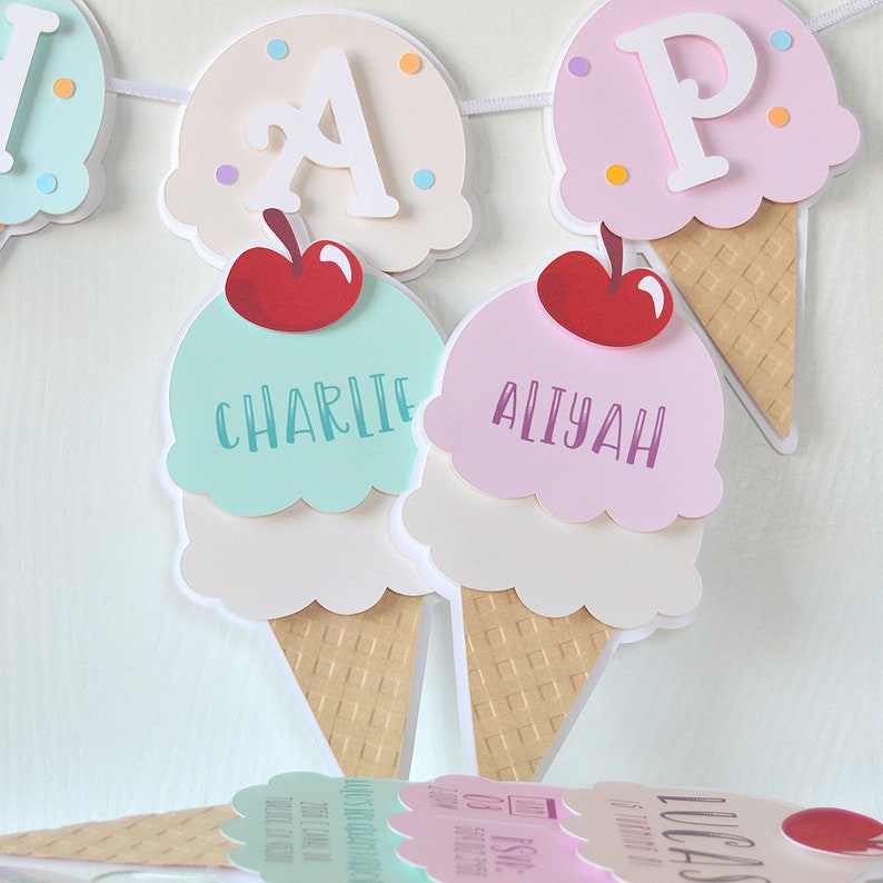 May include: A birthday banner with an ice cream cone theme. The banner has the letters "A" and "P" and the names "Charlie" and "Aliyah" on it.