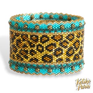 Peut inclure: Un large bracelet de perles avec un motif léopard. Le bracelet présente des perles turquoise, dorées et noires. Le bracelet mesure environ 5 cm de large.