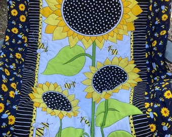 handmade quilt with bees and sun flowers, quilted onto a matching dark blue soft polyester quilt, pretty bees and sunflower quilted throw