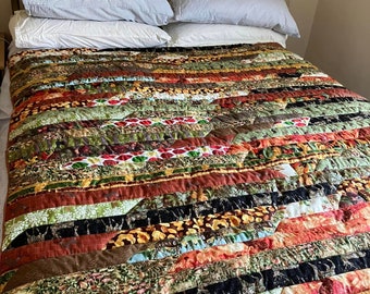 handmade patchwork quilt in autumn colours and stags, striped patchwork quilt sits on top of bed, patchwork sofa throw, rustic colours,