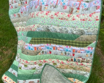 Handmade patchwork quilt made from pretty garden themed and green fabrics, lovely throw quilted onto soft green polyester fleece