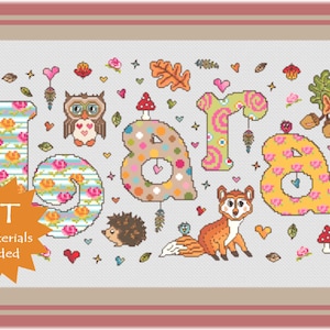 May include: Cross stitch kit featuring the name "Lara" in colourful letters with floral and animal designs. The kit includes all materials needed for the project.