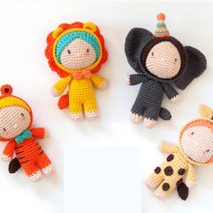 May include: Four crocheted stuffed animals dressed in animal costumes. The animals are a lion, elephant, tiger, and giraffe. The lion is wearing a yellow and orange costume, the elephant is wearing a gray costume, the tiger is wearing an orange and yellow costume, and the giraffe is wearing a yellow and brown costume.