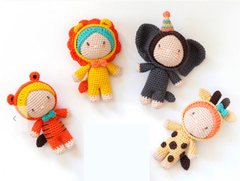 May include: Four crocheted stuffed animals dressed in animal costumes. The animals are a lion, elephant, tiger, and giraffe. The lion is wearing a yellow and orange costume, the elephant is wearing a gray costume, the tiger is wearing an orange and yellow costume, and the giraffe is wearing a yellow and brown costume.