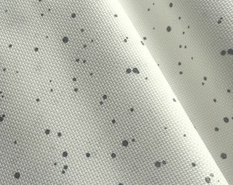 May include: White fabric with a subtle pattern of small black dots. The fabric has a textured surface.