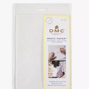 May include: A package of DMC Magic Paper, a white blank sheet for embroidery. The package is yellow and features the DMC logo and the text "Magic Paper" in black. The text "Blank Sheet - Feuille Vierge - Hoja en Blanco" is also included in black.