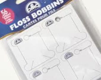 May include: A package of 56 white plastic floss bobbins. The bobbins are designed to hold embroidery floss and have a small hole at the top for threading.