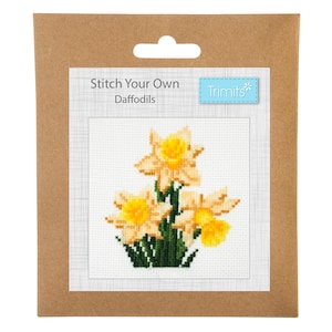 May include: A cross-stitch kit featuring a design of three yellow daffodils with green leaves. The kit is packaged in a brown cardboard envelope with the text "Stitch Your Own Daffodils" and "Trimits" printed on it.
