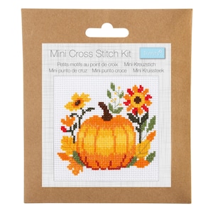 Könnte beinhalten: Ein Mini-Kreuzstich-Set mit einem Kürbis- und Blumendesign. Das Set wird in einer braunen Kartonverpackung geliefert und enthält den Text "Mini Cross Stitch Kit" sowie Text in mehreren Sprachen. Das Kreuzstich-Design zeigt einen Kürbis, Sonnenblumen und Blätter.