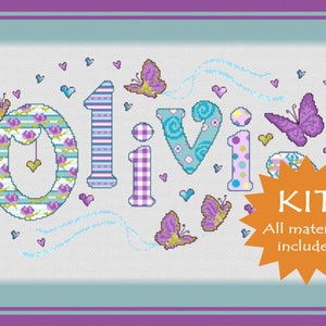 May include: Cross stitch kit featuring the name "Olivia" in colourful patterned letters with butterflies and hearts. The kit includes all materials needed for the project.