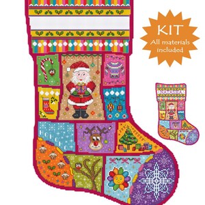 May include: A cross-stitch pattern of a Christmas stocking featuring a patchwork design with Santa Claus, a reindeer, a Christmas tree, and a snowflake. The top has a blank white space for a name. An orange starburst graphic says KIT All materials included.