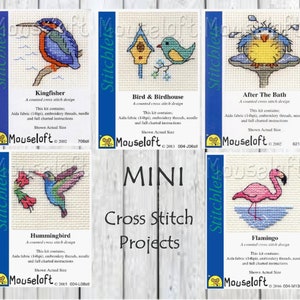 May include: Five counted cross stitch patterns for mini projects. The patterns include a kingfisher, a bird and birdhouse, a bath time duck, a hummingbird, and a flamingo. Each pattern is on a white card with a blue border and the name of the pattern printed below. The cards are arranged in a grid of three rows and two columns. The text "MINI Cross Stitch Projects" is printed in black letters on a white background in the center of the grid.