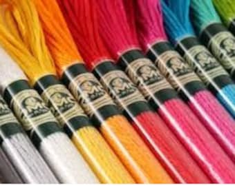 May include: Assortment of DMC embroidery floss spools in various colors, including grey, silver, yellow, orange, red, pink, blue, turquoise, and green.