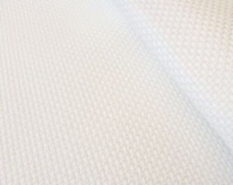 May include: White fabric with a subtle woven pattern. The fabric has a smooth texture and a slightly shiny finish.