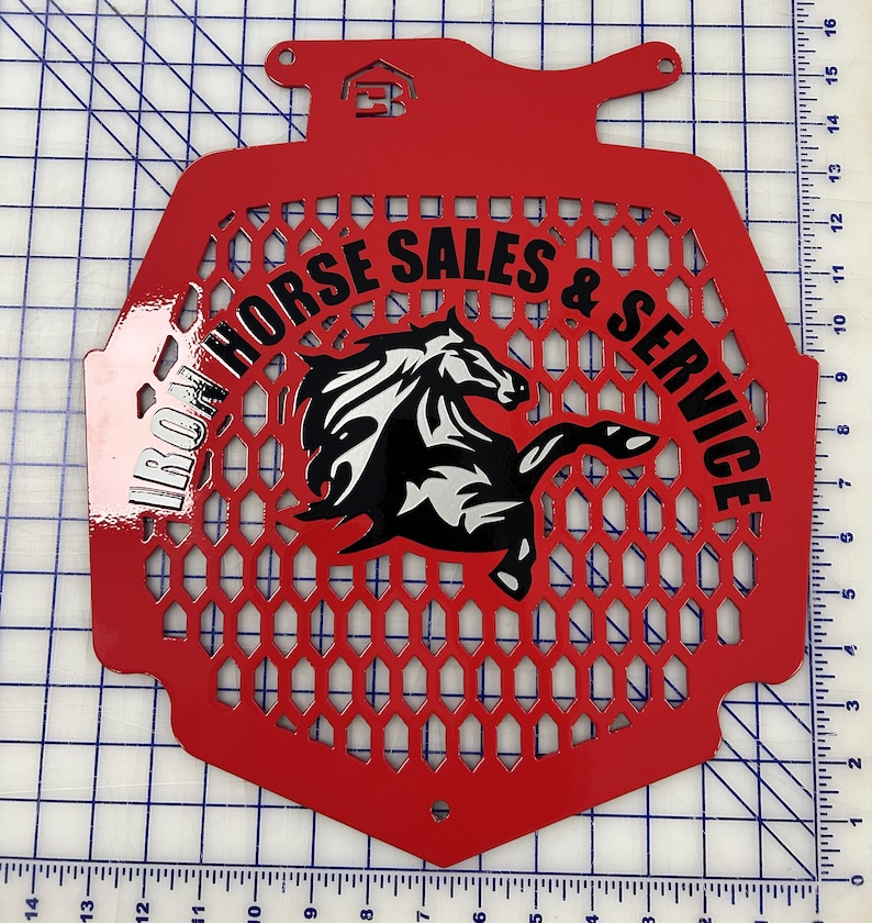 K&ouml;nnte beinhalten: Roter Metallgrill mit einem schwarzen und wei&szlig;en Pferdelogo und dem Text "IRON HORSE SALES & SERVICE".