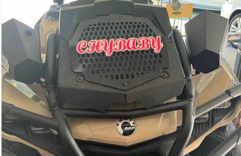 K&ouml;nnte beinhalten: Ein beiges Gel&auml;ndewagen mit einem schwarzen K&uuml;hlergrill und einem rosa-wei&szlig;en Aufkleber mit der Aufschrift "CHYBABY".
