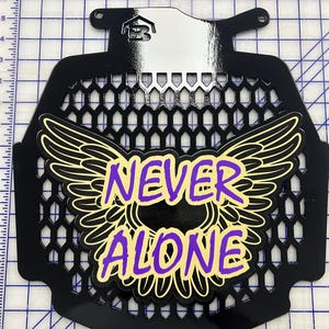 May include: Black metal grille with a yellow and purple graphic of wings and the words "NEVER ALONE".