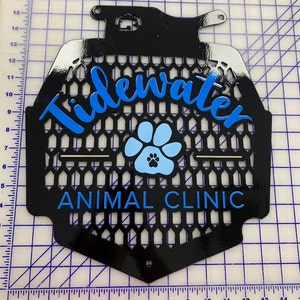 May include: Black metal sign with a blue paw print and the text "Tidewater Animal Clinic" in blue lettering.