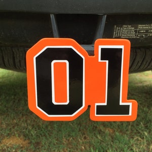 May include: Orange and black hitch cover with the number "01" in a white outline.