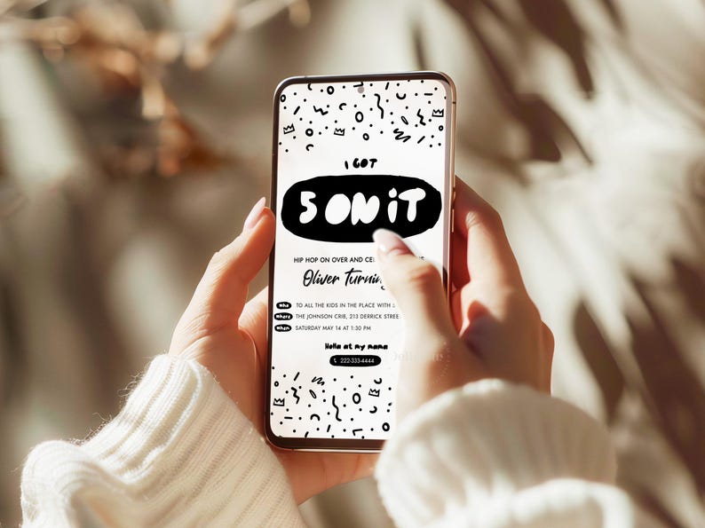 K&ouml;nnte beinhalten: Ein Smartphone zeigt eine digitale Einladung mit wei&szlig;em Hintergrund und schwarzen, handgezeichneten Kritzelmustern. Der Text lautet I GOT 5 ON IT, HIP HOP ON OVER AND CELEBRATE, Oliver Turning, TO ALL THE KIDS IN THE PLACE WITH, THE JOHNSON CRIB, 213 DERRICK STREET, SATURDAY MAY 14 AT 1:30 PM, Hello at my name und 222-333-4444.