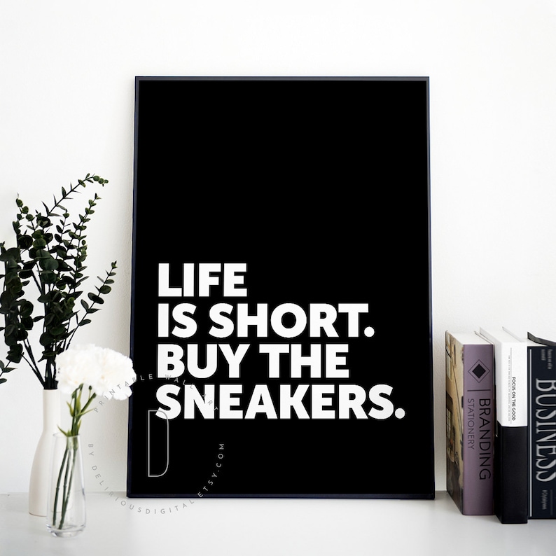 May include: Black and white typography poster with the text "Life is short. Buy the sneakers."