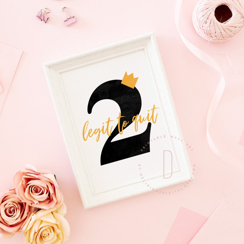 May include: A white framed print with a black number two with a gold crown on top. The text "legit to quit" is written in gold letters.