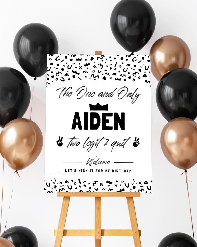 May include: A white rectangular birthday welcome sign on a wooden easel, surrounded by black and metallic bronze balloons. The sign features black text reading The One and Only AIDEN, two legit 2 quit, Welcome, and LET'S KICK IT FOR MY BIRTHDAY.