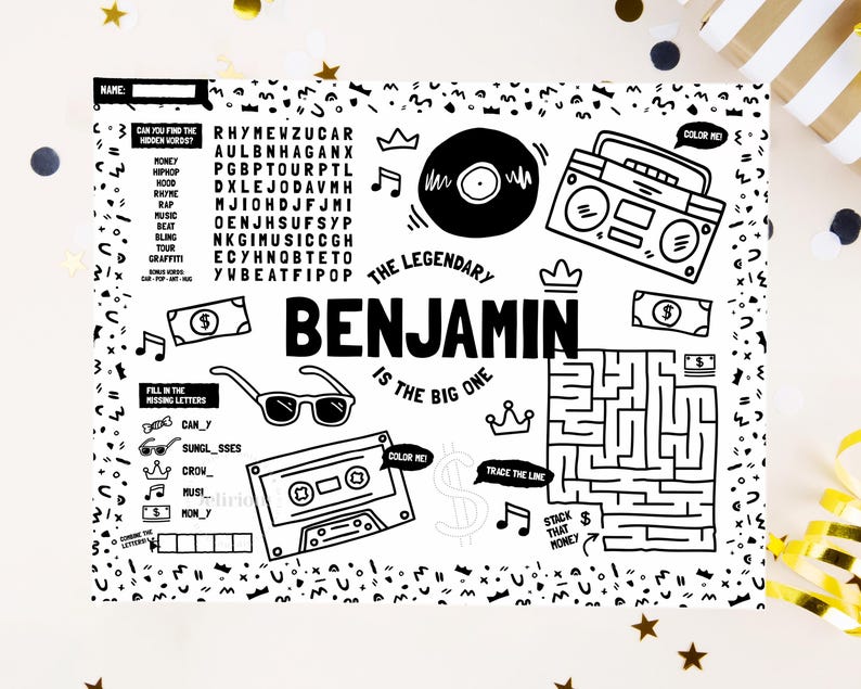 May include: A black and white activity placemat featuring the name Benjamin, a word search, a maze, and illustrations of a boombox, cassette tape, vinyl record, sunglasses, crowns, and dollar bills with the text The Legendary Benjamin Is The Big One.