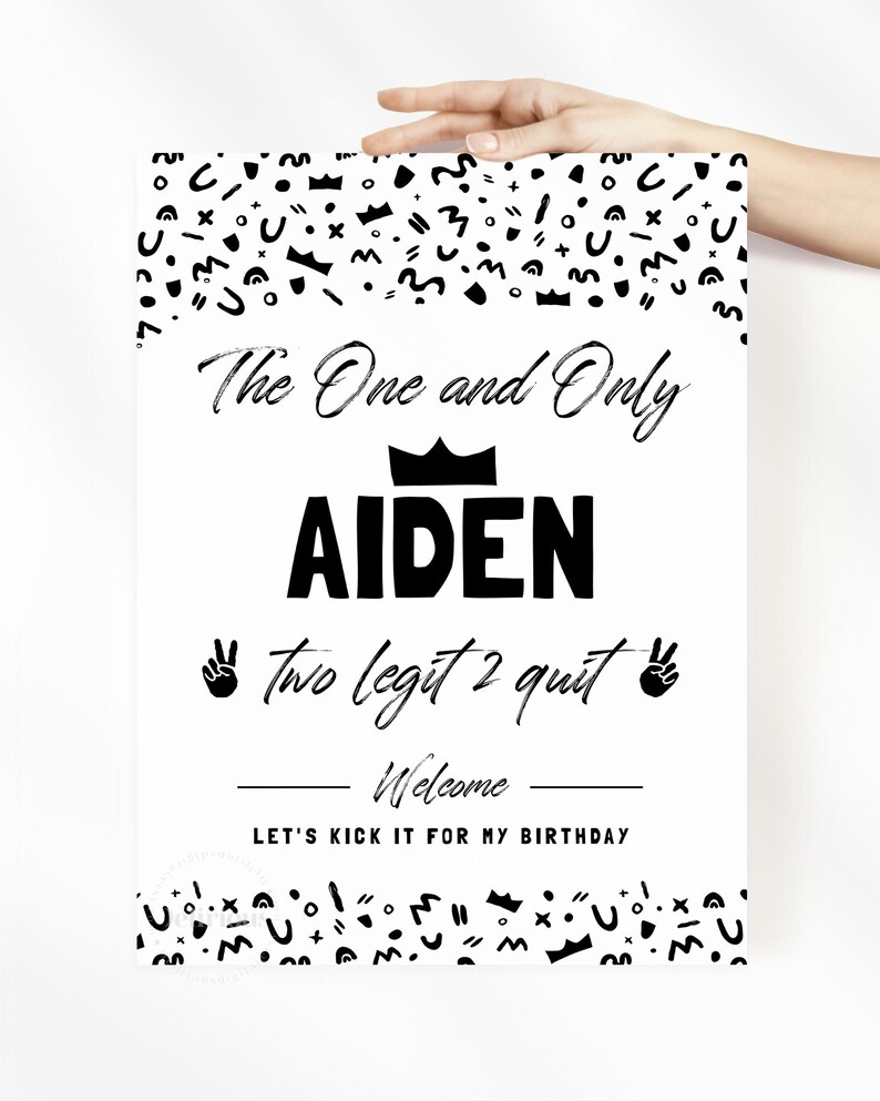 May include: A white rectangular sign with black text and abstract patterns. The text reads: The One and Only AIDEN, two legit 2 quit, Welcome, LET'S KICK IT FOR MY BIRTHDAY. A black crown icon sits above the name, and peace sign icons flank the text.