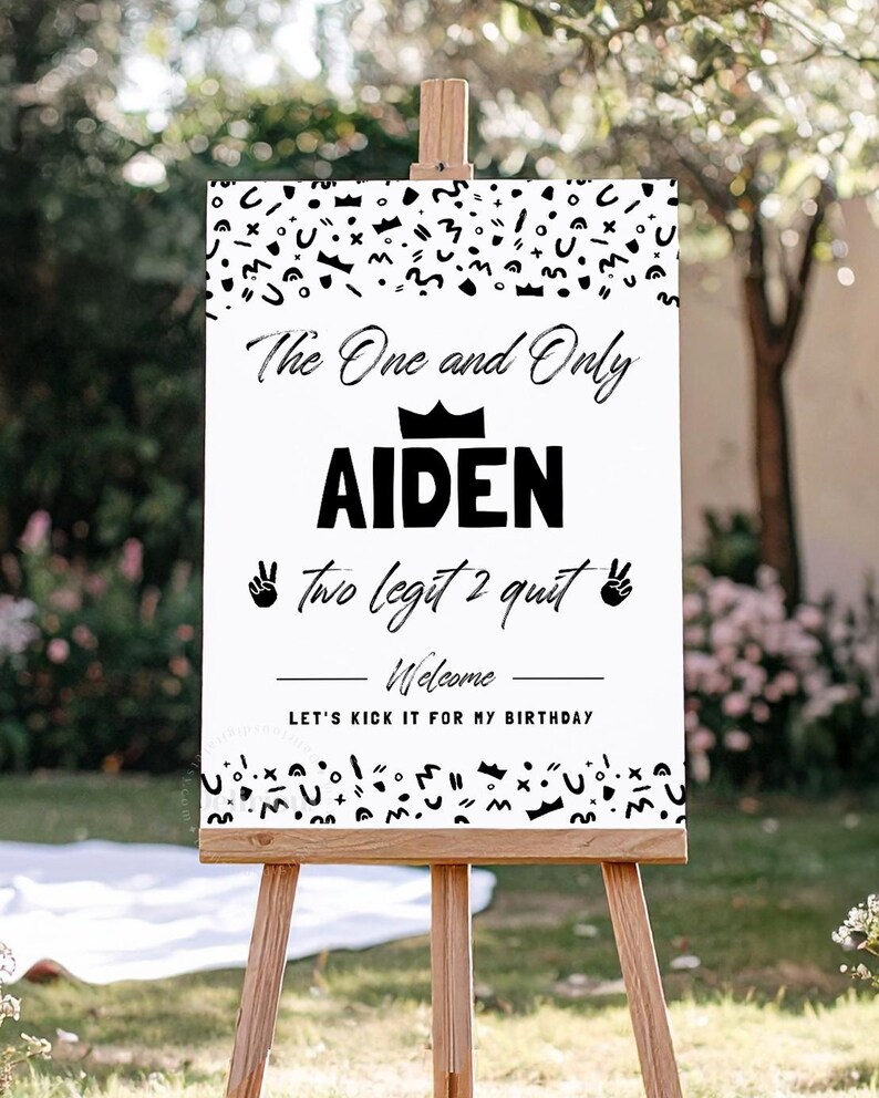 May include: A white rectangular birthday welcome sign on a wooden easel featuring black abstract shapes at the top and bottom, the text The One and Only AIDEN, a crown icon, the text two legit 2 quit with peace sign icons, and Welcome LET'S KICK IT FOR MY BIRTHDAY.