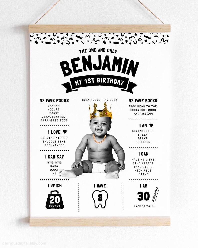 May include: A white poster with black text and graphics featuring a baby wearing a gold crown and chain. The text includes THE ONE AND ONLY BENJAMIN MY 1ST BIRTHDAY, birth date, favorite foods, books, personality traits, skills, 20 pounds, 8 teeth, and 30 inches tall.
